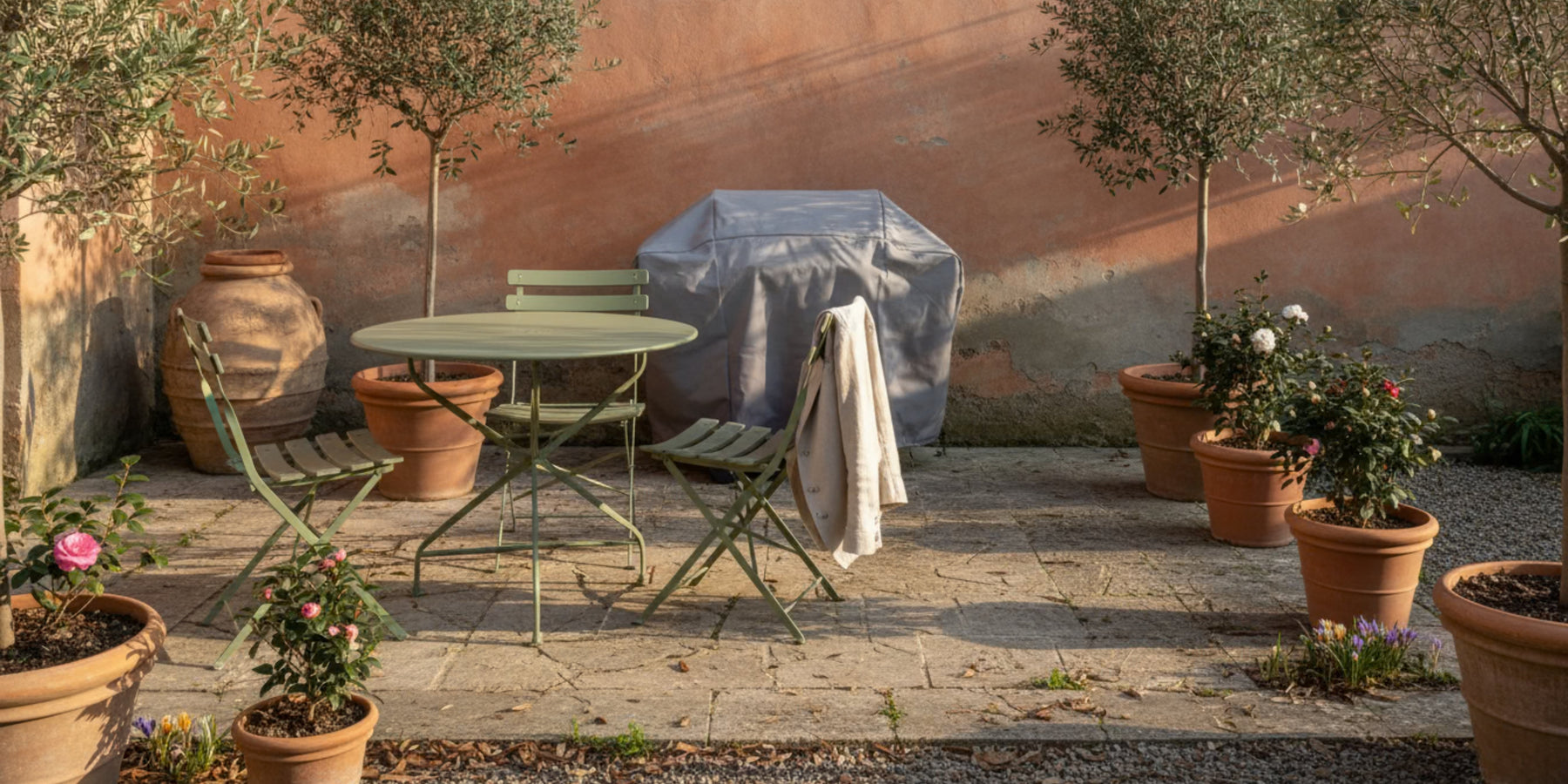 Terrazzo con area outdoor in fase di preparazione dopo l’inverno, con arredi esterni e barbecue pronti per la primavera